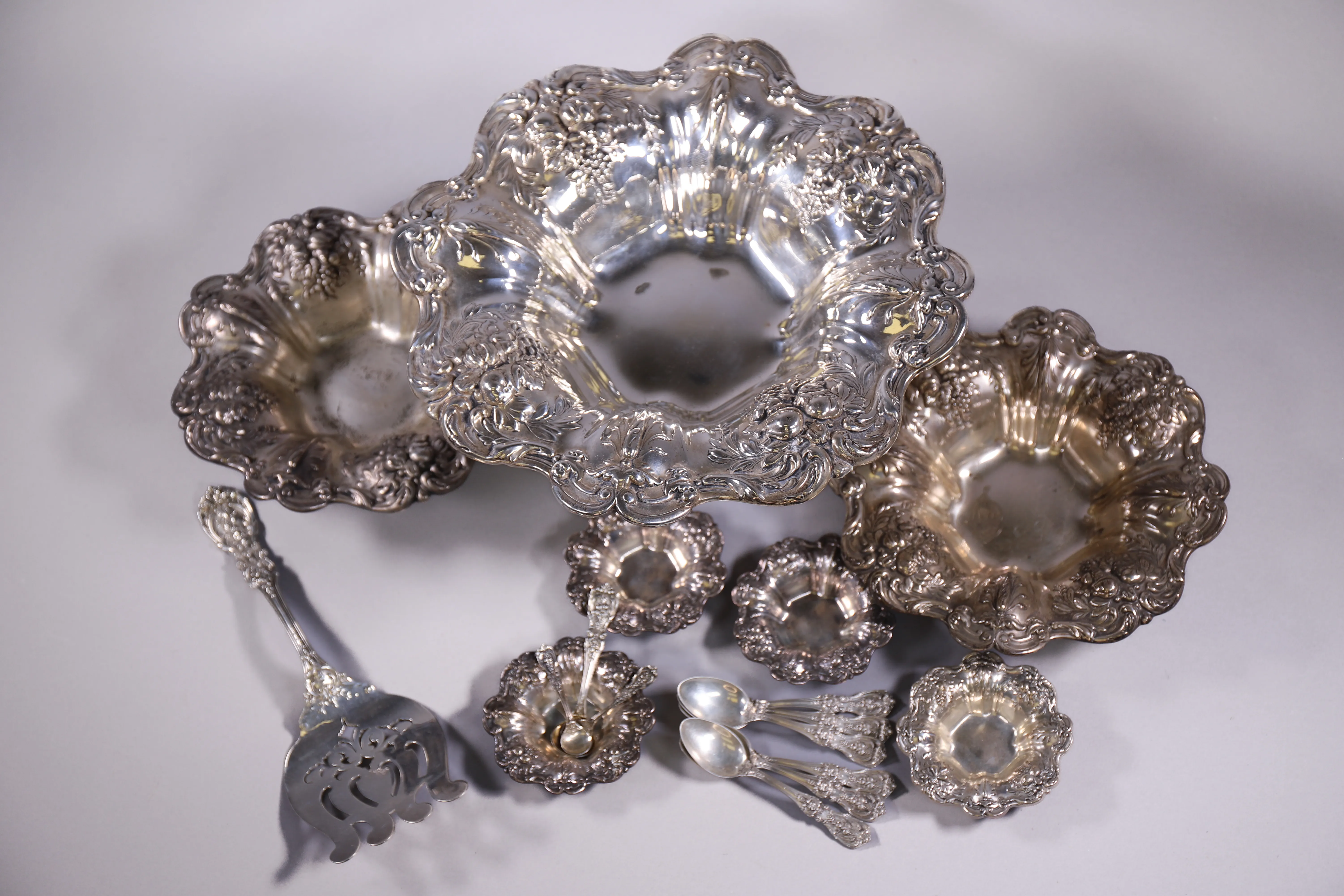 Polished silver service pieces arranged for estate sale presentation.
